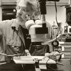 David Dunn working with electronics and a microscope in his studio