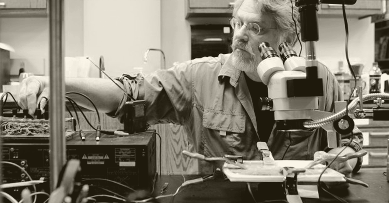 David Dunn working with electronics and a microscope in his studio