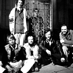 Composers Inside Electronics group photo at the ICA, with David Tudor visible through a metal lattice sculpture