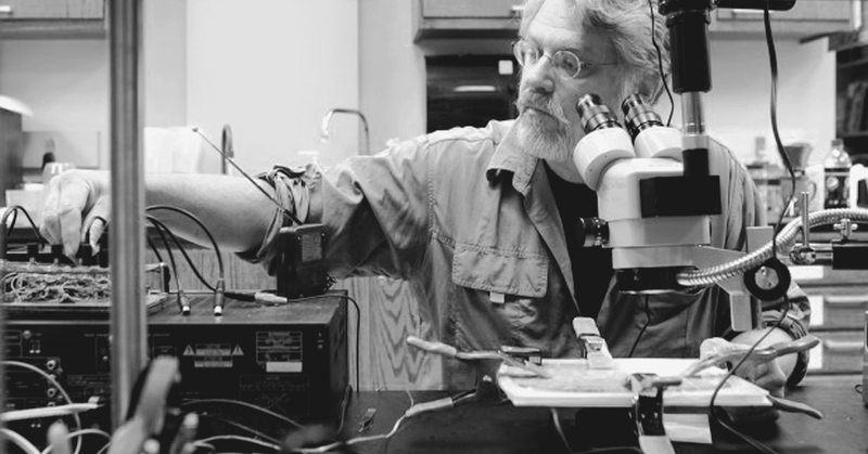 David Dunn working with electronics and a microscope in his studio