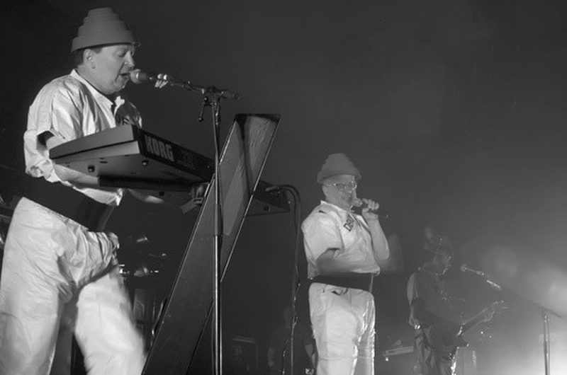 Devo performing live in their Energy Dome hats and yellow jumpsuits, 2009