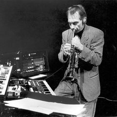 Jon Hassell playing trumpet through an effects rig, mixing console in the foreground
