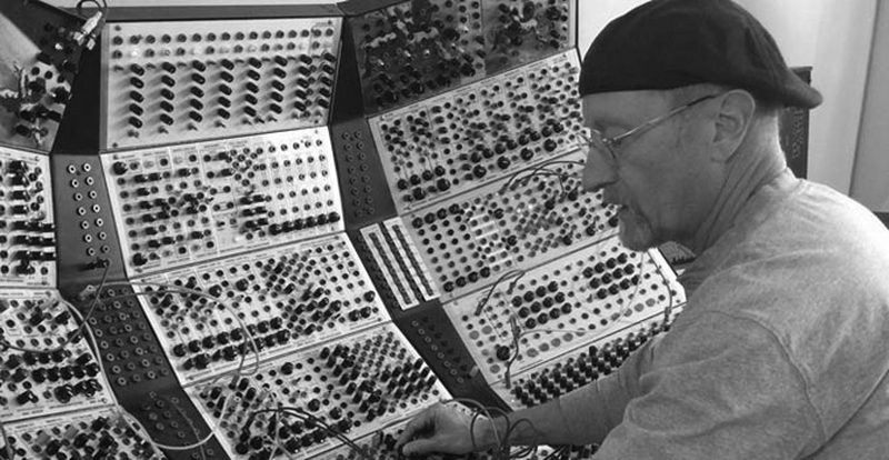 Black-and-white photograph of Kevin Fortune working at a Serge modular system
