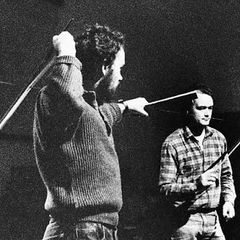 Still from Kick That Habit: two musicians bowing long wires as instruments
