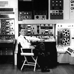 Raymond Scott seated among his reel-to-reel tape machines and electronic music equipment