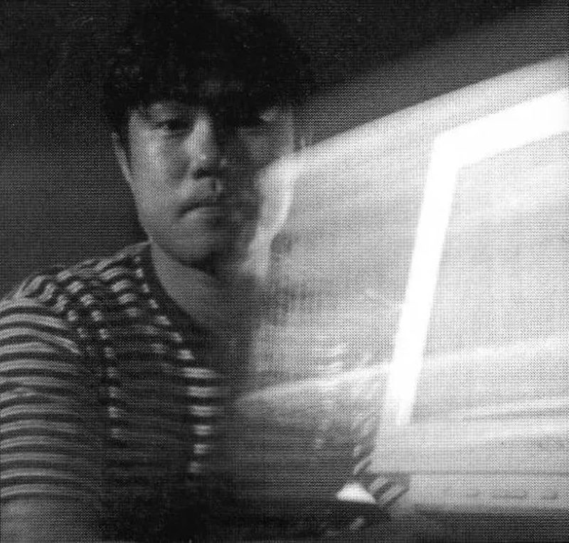Tetsu Inoue lit by the glow of a monitor