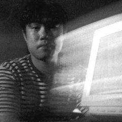 Tetsu Inoue lit by the glow of a monitor