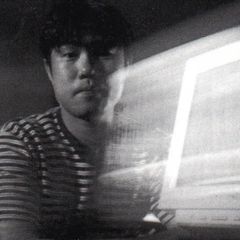 Tetsu Inoue lit by the glow of a monitor